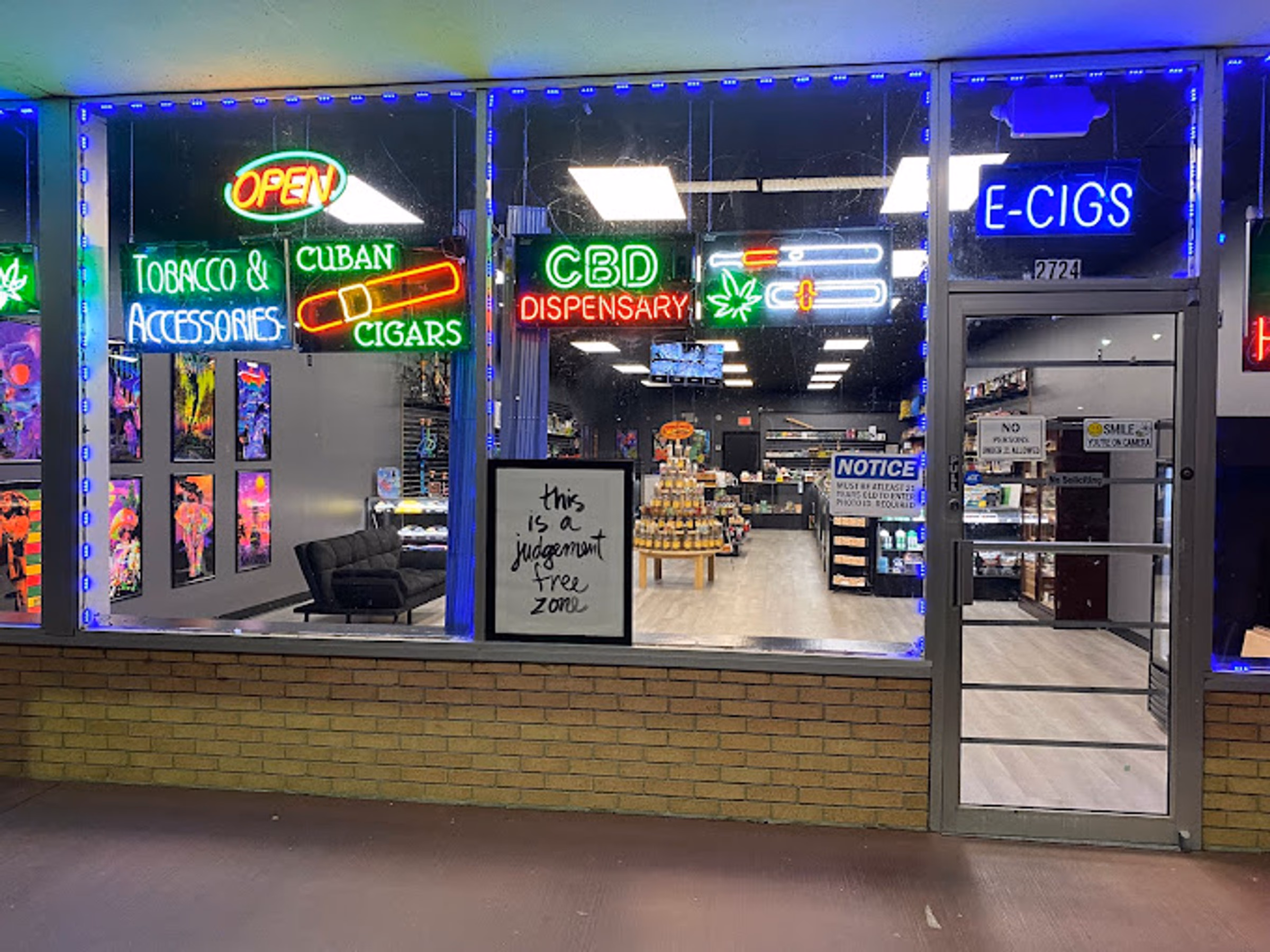 Metro Smoke Shop storefront at night at 2724 W Old US Highway 441, Mount Dora, with neon window signs lit